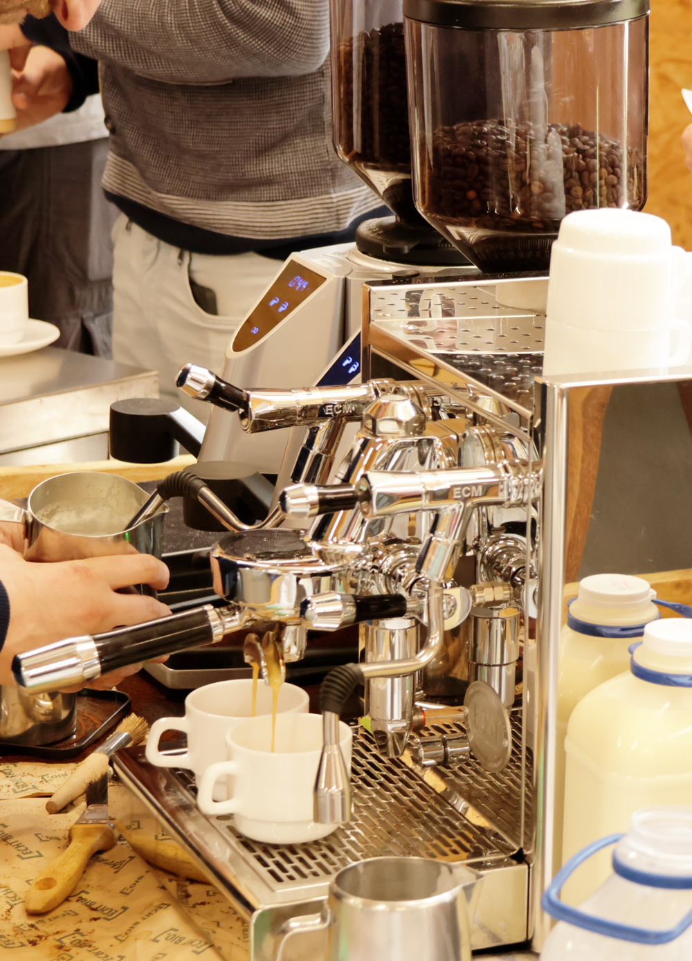 Personen bereiten Kaffeegetränke zu